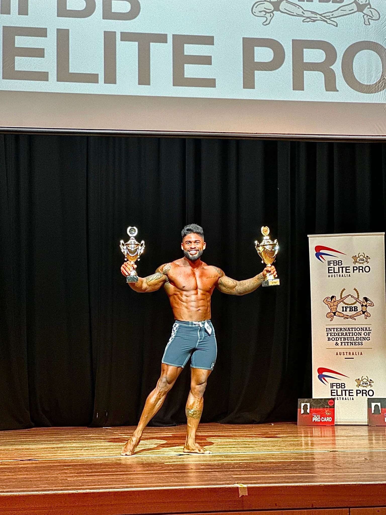 Ronan Costa holding two trophies on stage